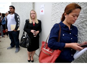 Kelli Harker, formerly an engineering technologist with an oil and gas firm, lines up outside the Coast Plaza Hotel in Calgary, Alta., on Wednesday August 17, 2016, during the Calgary Airport Authorities job fair to find workers for when they open the new terminal. Leah Hennel/Postmedia