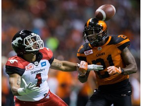 Calgary Stampeders' Lemar Durant, left, watches the ball but fails to make the reception as B.C. Lions' Ryan Phillips grabs his arm during the second half of a CFL football game in Vancouver, B.C., on Friday August 19, 2016.