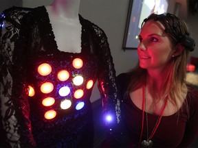 Angie Coombes stands next to a wearable technology dress she created that reacts to the user's brain wave patterns at the Mini Maker Faire held at the Telus Spark World of Science in Calgary on Sunday August 21, 2016. The annual two-day festival hosts local inventors and their creations.