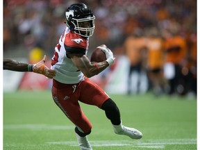 Calgary Stampeders' Marquay McDaniel runs with the ball as B.C. Lions' Alex Bazzie reaches to stop him during the second half of a CFL football game in Vancouver, B.C., on Friday August 19, 2016.