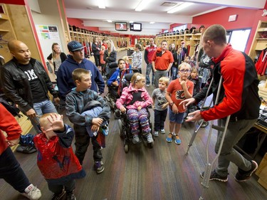 A crowd of Make-A-Wish Foundation families are given a tour of the Calgary Stampeders' locker room during a Stamps practice at McMahon Stadium in Calgary, Alta., on Thursday, Aug. 25, 2016. About 30 kids with the Make-A-Wish Foundation of Southern Alberta watched a team practice, toured the Stampeders' locker room and met the players.