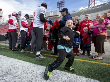Skyeler McConachie guns a pass as Calgary Stampeders sign autographs behind him after a team practice at McMahon Stadium in Calgary, Alta., on Thursday, Aug. 25, 2016. About 30 kids with the Make-A-Wish Foundation of Southern Alberta watched a team practice, toured the Stampeders' locker room and met the players. Lyle Aspinall/Postmedia Network
