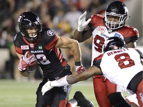 Calgary Stampeders' Micah Johnson (93) keeps his eye on the ball as teammate Fred Bennett (8) lunges at Ottawa Redblacks receiver Greg Ellingson (82) during the second half of a CFL football game in Ottawa on July 8, 2016.