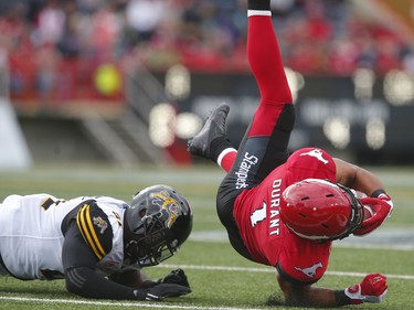 Calgary Stampeders Lemar Durant is tackled by Simoni Lawrence of the Hamilton Tiger-Cats during CFL football in Calgary, Alta., on Sunday, August 28, 2016. AL CHAREST/POSTMEDIA