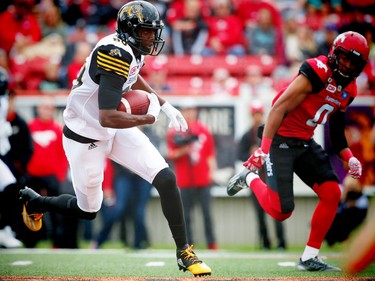 Hamilton Tiger-Cats Terrance Toliver avoids a tackle by Ciante Evans of the Calgary Stampeders during CFL football in Calgary, Alta., on Sunday, August 28, 2016. AL CHAREST/POSTMEDIA