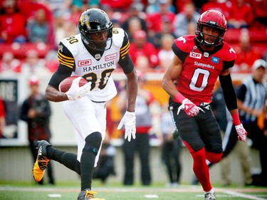 Hamilton Tiger-Cats Terrance Toliver avoids a tackle by Ciante Evans of the Calgary Stampeders during CFL football in Calgary, Alta., on Sunday, August 28, 2016. AL CHAREST/POSTMEDIA