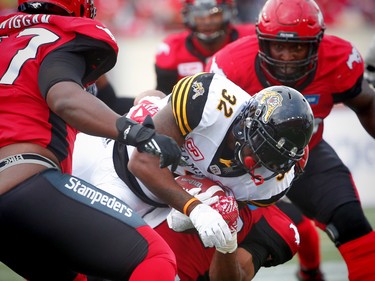 Hamilton Tiger-Cats C.J. Gable is brought down by the Calgary Stampeders during CFL football in Calgary, Alta., on Sunday, August 28, 2016. AL CHAREST/POSTMEDIA