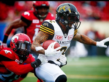 Hamilton Tiger-Cats Chad Owens avoids a tackle by Brandon Smith of the Calgary Stampeders during CFL football in Calgary, Alta., on Sunday, August 28, 2016. AL CHAREST/POSTMEDIA