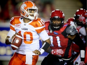 B.C. Lions quarterback Jonathon Jennings is chased out of the pocket by Demonte Bolden of the Calgary Stampeders during CFL football in Calgary on July 29, 2016.