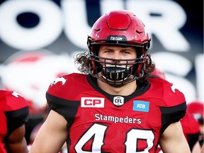 Calgary Stampeders Alex Singleton runs onto the field during player introductions before facing the Saskatchewan Roughriders in CFL football in Calgary, Alta., on Thursday, August 4, 2016. AL CHAREST/POSTMEDIA
