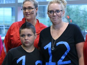 Rachelle Christopher (back left ) is joined by Karine Ruiz (R) and Bryson Ruiz outside of the Calgary Courts Centre in Calgary, Alta on Wednesday August 3, 2016. A small group of Taradale residents had the number 12 marked on their faces and wore shirts to protest the sentence handed down to the Manyshot brothers in a rape case. A spokesperson for the group feel a reduced sentence would be a " glaring failure of the justice system." Jim Wells//Postmedia