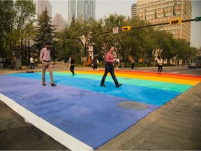 Pedestrians cross the cityÕs very first rainbow crosswalk, painted in preparation for the upcoming 25th Annual Calgary Pride Festival, at city hall in Calgary on Tuesday, Aug. 25, 2015.