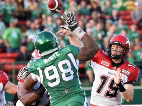 Saskatchewan Roughriders defensive lineman Markus White (#98) tips a pass by Calgary Stampeders quarterback Bo Levi Mitchell (#19) during CFL preseason action at Mosaic Stadium in Regina on June 19, 2015. The Stampeders will play their final game at Mosic Stadium on Saturday.