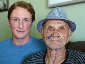 Ryan Czenczek and his grandfather Ken pose in the family's NE Calgary, Alta home on Sunday August 14, 2016. Ken was apparently hit in the face with a glass by a stranger who entered the home late on Friday night. The grandson found the senior bleeding in the kitchen and took him to hospital for treatment. Jim Wells/Postmedia