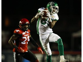 Saskatchewan Roughriders' Ryan Lankford, right, comes down with a pass as Calgary Stampeders' Jamar Wall looks on during second half CFL football action in Calgary, Thursday, Aug. 4, 2016.