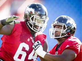 Derek Dennis (L) works against Ucambre Williams during the Calgary Stampeders training camp at McMahon Stadium in Calgary, Alta., on Tuesday, May 31, 2016.