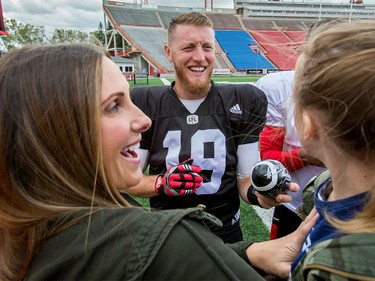 Calgary Stampeders quarterback Bo Levi Mitchell signs autographs for Make-A-Wish Foundation kid Ivy Scott and her mom Nena after a Calgary Stampeders practice in Calgary, Alta., on Thursday, Aug. 25, 2016. About 30 kids with the Make-A-Wish Foundation of Southern Alberta watched a team practice, toured the Stampeders' locker room and met the players.