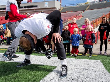 Adam Thibault passes a ball to a a trio of boys after a Calgary Stampeders practice in Calgary, Alta., on Thursday, Aug. 25, 2016. About 30 kids with the Make-A-Wish Foundation of Southern Alberta watched a team practice, toured the Stampeders' locker room and met the players.