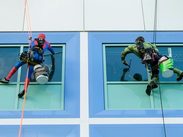 Spiderman and the Hulk wash windows the Alberta Children's Hospital in Calgary on Wednesday, Aug. 24, 2016. The washers refused to identify their secret identities, opting instead to wow kids through windows while cleaning the hospital's exterior.
