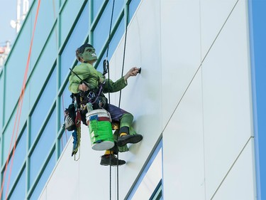 The Hulk washes windows at the Alberta Children's Hospital in Calgary on Wednesday, Aug. 24, 2016. Four super-hero window washers refused to identify their secret identities, opting instead to wow kids through windows while cleaning the hospital's exterior.