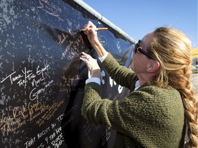 Kathy Gammon signs a large thank-you poster at a CJAY 92 booth before a Tragically Hip concert at the Scotiabank Saddledome in Calgary, Alta., on Monday, Aug. 1, 2016.