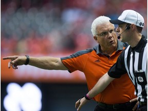 B.C. Lions' head coach Wally Buono, left, protests a call to an official during the first half of a CFL football game against the Calgary Stampeders in Vancouver, B.C., on Friday August 19, 2016.