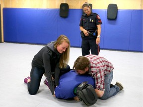 Calgary media, including Postmedia's Michael Lumsden (R), participate in a compliance demonstration at CPS headquarters.