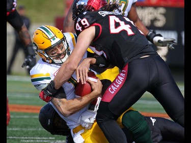 Edmonton Eskimos quarterback Mike Reilly is sacked by Calgary Stampeders Frank Beltre and Alex Singleton during the first half of the CFL Labour Day Classic in Calgary on Monday September 5, 2016.