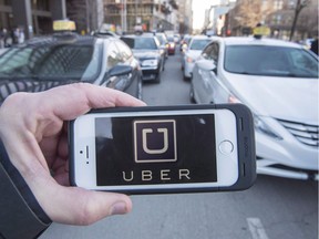 The Uber logo is seen in front of protesting taxi drivers at the Montreal courthouse, on February 2, 2016. Calgary city council has passed a bylaw that would allow for the operation of ride-sharing companies, but officials with Uber say the rules are too strict. THE CANADIAN PRESS/Ryan Remiorz