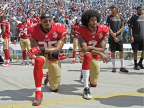 San Francisco 49ers' Colin Kaepernick (7) and Eric Reid (35) kneel during the national anthem before an NFL football game against the Carolina Panthers in Charlotte, N.C., Sunday, Sept. 18, 2016. (AP Photo/Mike McCarn) ORG XMIT: NCCB103