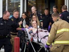 A police officer is wheeled on a stretcher out of the Sears in Marlborough Mall in Calgary, Alta., on Saturday, Sept. 17, 2016. There were rumours of a man wielding a machete in the area, but official details on the incident were not immediately made known. Lyle Aspinall/Postmedia Network