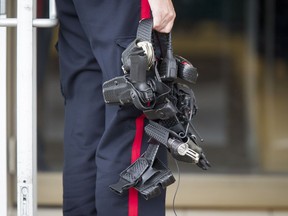 A police officer's belt is held by a colleague outside of Sears in Marlborough Mall in Calgary, Alta., on Saturday, Sept. 17, 2016. A police officer was seen being wheeled out of the store on a stretcher.