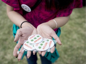 A woman holds pins supporting the legalization of marijuana at the Fill the Hill marijuana rally on Parliament Hill in Ottawa on Sunday, April 20, 2014.