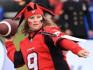Chelsea Thiessen, 10, makes a pass in a fan zone before the CFL Labour Day Classic between the Calgary Stampeders and Edmonton Eskimos in Calgary on Monday September 5, 2016.