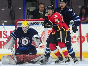 Calgary Flames' Ryan Lomberg (56) Winnipeg Jets' goalie Jamie Phillips (50) and Nelson Nogier (62) during third period 2016 NHL Young Stars Classic action at thin front of e South Okanagan Events Centre in Penticton, B.C., on Sept. 16, 2016.