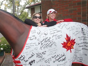 Olympians Tiffany Foster, left, and Amy Millar, pose beside a blanket signed by members of the public wishing Team Canada well before the Rio Olympics Tuesday September 6, 2016 at Spruce Meadows. Spruce Meadows is gearing up to close the season with this week's The Masters. (Ted Rhodes/Postmedia)