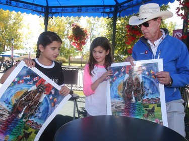Vancouver Island twins Mackenzie and Quinn Hoar get their posters signed by Canadian retired legend Ian Millar during an autograph session Friday September 9, 2016 at Spruce Meadows during The Masters.