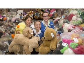 Girl Guides, from left, Morgan Kuzuchar, age 12, Adrianah Bollhorn, 11 and Petra Bollhorn, 14, gather amidst the thousands of teddy bears collected in the annual Share Your  Bear campaign at Girl Guide HQ Friday September 23, 2016. The Guides partner with Calgary Police, Kids Help Phone and MaxWell Realty to collect stuffed animals to be used with children who experience trauma. (Ted Rhodes/Postmedia)