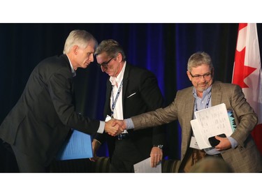 Hal Kvisle, co-chair of the 2016 Global Business Forum, right, shakes hands with speakers Rich Crothers, left of Shell Canada, and, centre, Rich Kruger of Imperial Oil  following the Energy's Future panel Friday September 30, 2016 at the Banff Springs Hotel.