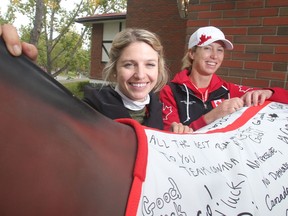 Olympians Tiffany Foster, left, and Amy Millar, pose beside a blanket signed by members of the public wishing Team Canada well before the Rio Olympics Tuesday September 6, 2016 at Spruce Meadows. Spruce Meadows is gearing up to close the season with this week's The Masters. (Ted Rhodes/Postmedia)