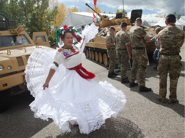 Rosa Thomson kicks up her heels in an impromptu dance at the British military display Wednesday September 7, 2016 on the opening day of The Masters at Spruce Meadows. She is with the Marakame Mexican Dance and Art Association. Behind her is the British armoured fighting vehicle.