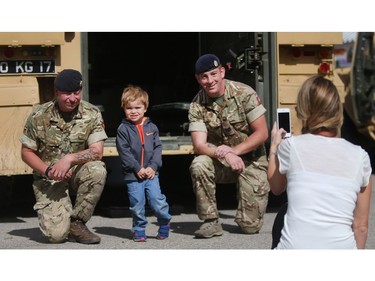 Charlie Dawson has his picture taken by his mom Allison along with British servicemen Corporal Richard Dellar, left, and Sergeant Charlie Corderoy and the armoured fighting vehicle on display Wednesday September 7, 2016 on the opening day of The Masters at Spruce Meadows.