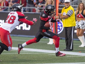 Chris Williams runs for a touchdown with Brandon Smith of Calgary in pursuit in the 1st quarter as the Ottawa Redblacks take on the Calgary Stampeders in CFL action at TD Place Stadium at Lansdowne Park in Ottawa.  Wayne Cuddington/ Postmedia
