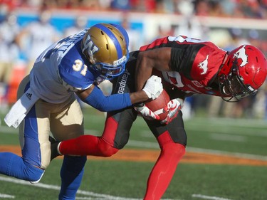 Stampeders Kamar Jorden tries to haul in a catch in front of Blue Bomber defender Tony Burnett during CFL action between the Calgary Stampeders and the Winnipeg Blue Bombers in Calgary, Alta. on Saturday September 24, 2016. Jim Wells/Postmedia