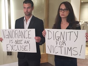 Sexual assault survivor Jessica Daigle and her boyfriend, Donald Walker, display placards they made to protest Justice Robin Camp's conduct in a sexual assault trial. Camp is facing a Canadian Judicial Council inquiry into his conduct.
