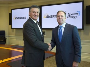 Enbridge Inc. president and CEO Al Monaco, left, and Greg Ebel, chairman, president and CEO of Spectra Energy Corp.,shake hands after announcing a $37-billion merger on Tuesday.