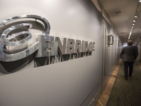 An Enbridge employee walks past signage at the head office in Calgary, on September 6, 2016.