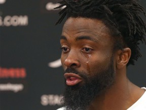 Calgary Stampeder Joshua Bell sheds a tear during a press conference in Calgary on Sunday, September 25, 2016 as he speaks about fellow player Mylan Hicks, who was killed in a shooting outside a nightclub early Sunday morning.