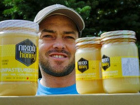 Beekeeper Kevin Nixon holds a selection of his honey at his apiary near Innisfail, Alta., Thursday, Sept. 1, 2016. Canadian honey producers are being stung with 50 per cent lower prices as they finish harvesting their 2016 crop, a devastating blow that some are blaming on a global glut of cheap, low-quality Chinese exports.