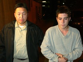 Dustin Loran is escorted by a police officer after his arrest in September 2005.